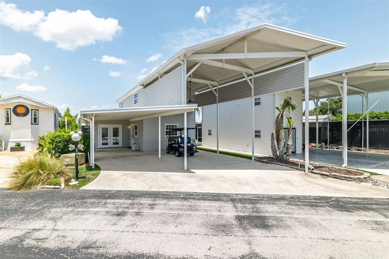 Front of the golf course home with a covered carport and golf cart